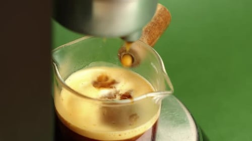 Espresso Coffee Dripping From Machine Into Glass
