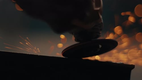 Angle Grinder Cutting Metal with Bright Sparks in Dark Workshop Silhouette Slow Motion