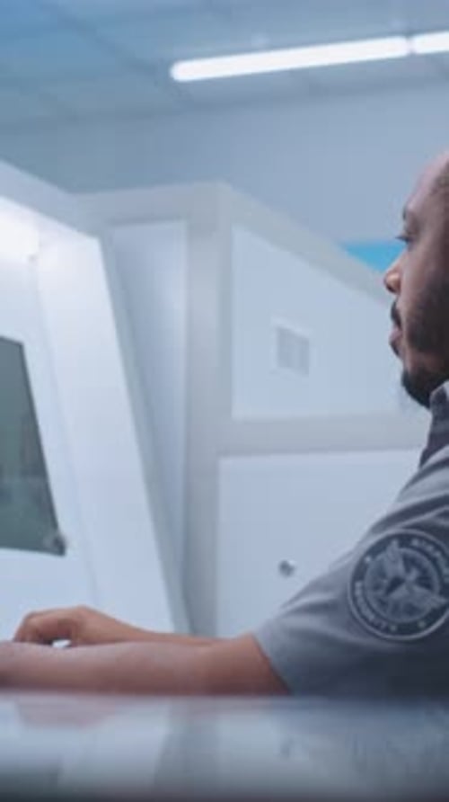 Airport Security Checkpoint Security Officer Monitors Baggage Screening on Computer Screens