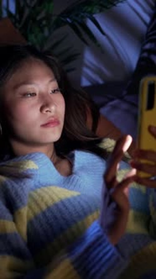 Earnest Asian Girl Lying on Sofa at Home Using Cell Phone Serious Discouraged Young Chinese Woman