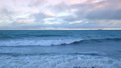 Meer oder Meer mit Wellen, die gegen die Küste schlagen, die Morgendämmerung bricht am Horizont zusammen und sorgt für eine heitere Atmosphäre