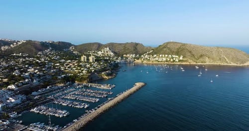 Rising Drone Shot Over Beautiful Mediterranean Town And Bay With Boats Parked