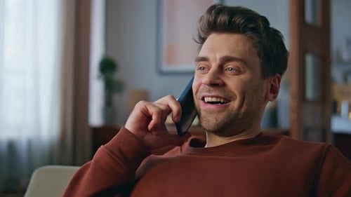 Man Laughing and Talking on Phone at Home