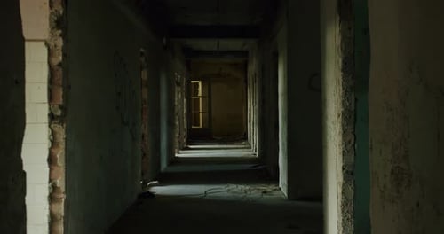 Dark Corridor of a Semi-Demolished Industrial Building with Light Peaking through Each Room