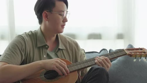 Man Plays Guitar on Couch