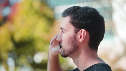 Young Man Talking on Cell Phone Outdoors
