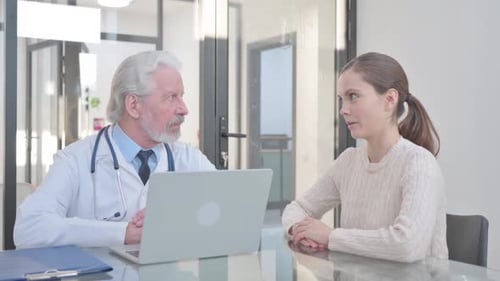 Doctor Consults with Young Adult Patient in Office