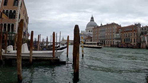 A wide shot of a dock with boats and gondolas in a Venice, Italy