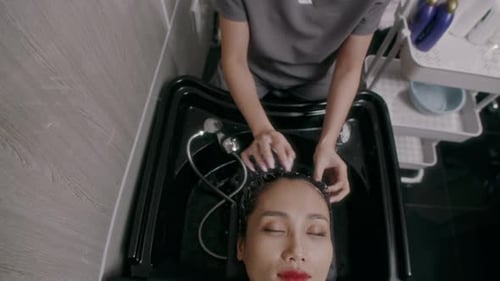 Woman Enjoying Hair Wash Procedure in Beauty Center Top View