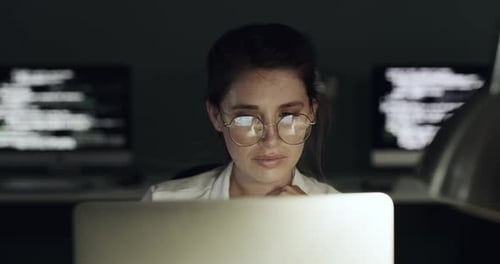 4K-Videomaterial einer jungen Frau, die einen Laptop benutzt, um eine Netzwerkaufgabe zu erledigen