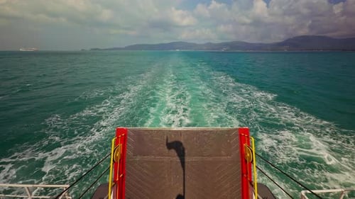 View From Ferry Stern Showing Foamy Wake Cutting Through Open Sea Toward Distant Islands Under