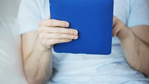 Man Uses Tablet Computer in Blue Case