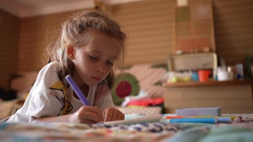 Girl Drawing with Marker on Paper in Room