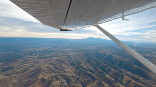 Un avion Cessna 182 survolant la chaîne de montagnes du Colorado pendant une journée nuageuse