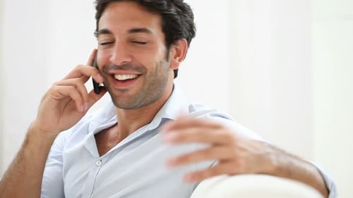 Man talking on phone smiling indoors close up