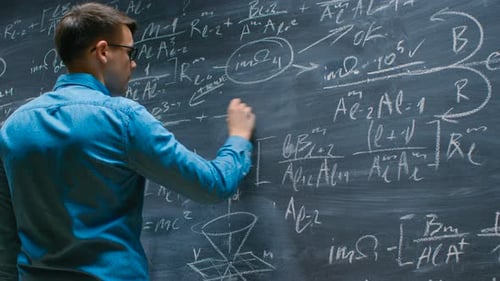 Brilliant Young Mathematician Approaches Big Blackboard and Finishes writing Sophisticated Mathema