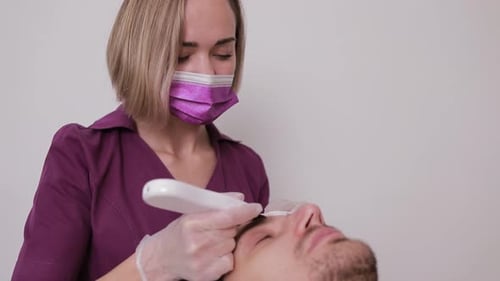 A Professional Facial Skin Care Session for a Man is Being Conducted in a Modern Beauty Clinic with