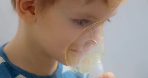 Young Boy Using Nebulizer Mask for Respiratory Treatment