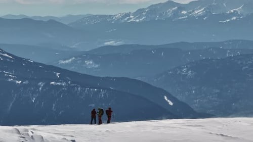 Bergsteiger stehen auf dem verschneiten Bergrücken und genießen die malerische Aussicht