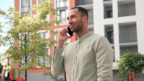 Man Talking on Phone Outside Modern Building
