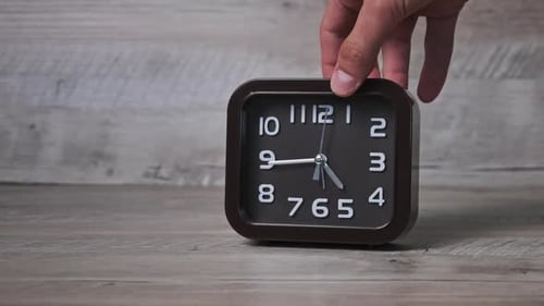 Male Hand Puts an Arrow Mechanical Watch on a Wooden Table