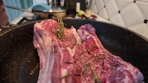 Seasoning Raw Meat with Rosemary in Pan