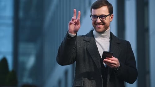 Auburn Haired Man Using Smartphone Outside Modern Building