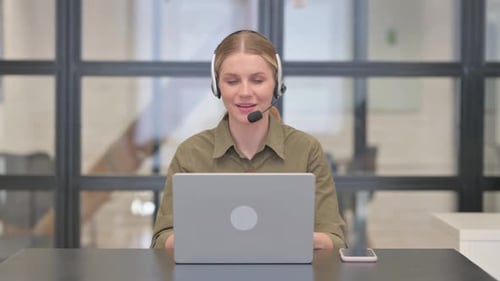 Mature Adult Woman with Headset Talking Online with Customer in Call Center