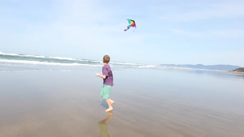 Young Boy Flying Kite at Beach Active