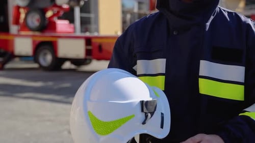 Firefighter Putting on Helmet Near Fire Truck