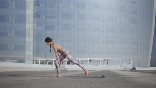 Yoga woman stretching body on city street in slow motion fitness training outdoors