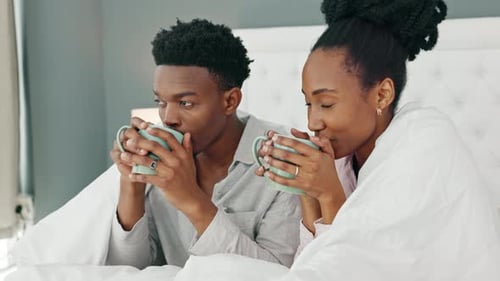 Couple Relaxing in Bed, Drinking Coffee Together