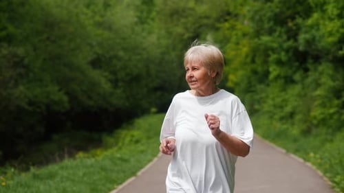 Active Seniors are Depicted As an Elderly Woman Jogs Through the Park