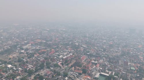 Aerial drone view of Chiang Mai covered in smog during burning season, highlighting severe air