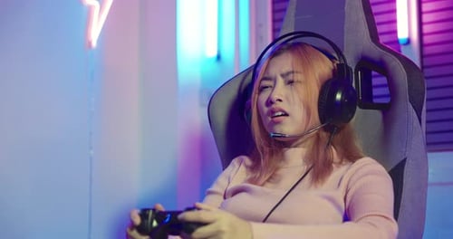 Gamer in play video game online with joystick on computer neon lights she fail game over