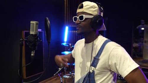 Young african american artist recording music in professional studio