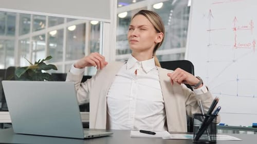 Woman Stretching at Desk in Bright Office