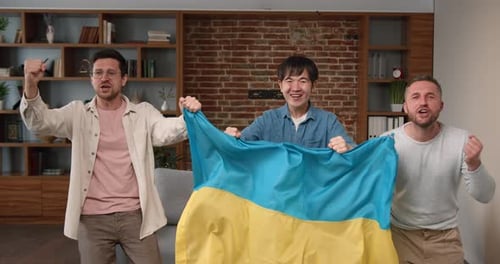 Enthusiastic Friends Cheer with Flag Indoors