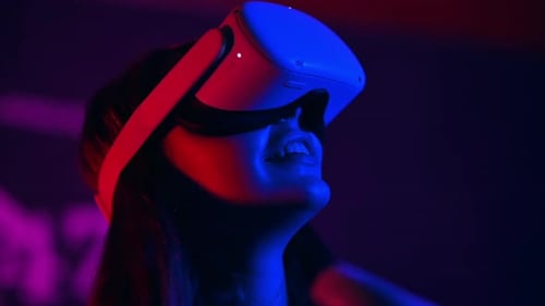 Woman Wearing Virtual Reality Headset in Neon Lit Room