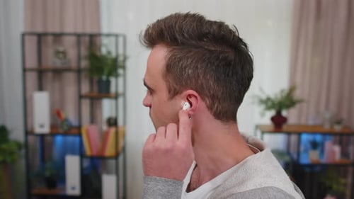 Happy Relaxed Man Wearing Wireless Earphones Dancing Listening Favorite Rock n Roll Music at Home