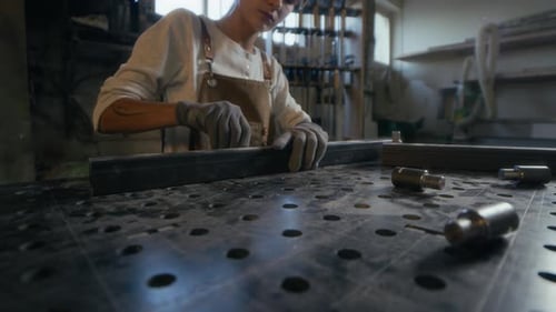 Frau baut Metallkonstruktion in der Werkstatt