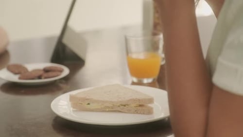 Boy Eating Breakfast at Kitchen Table With Mother