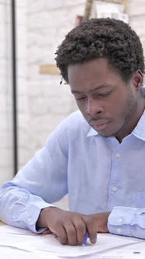 Man Reviews Documents in Office with Pen
