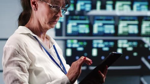Woman Uses Tablet in Tech-Filled Office Environment