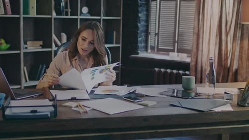 Businesswoman analyzing financial report documents in home office studio