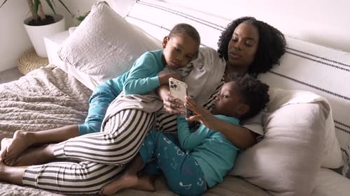 Mother and Sons Relaxing and Using Mobile Phone