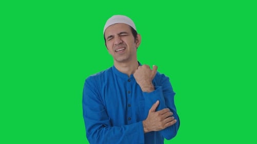 Sick Muslim man suffering from hand pain Green screen