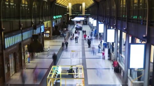 Timelapse of the exterior of the train station. People move fast inside the building.