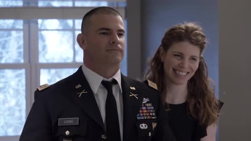 Woman helping man in US Army uniform prepare