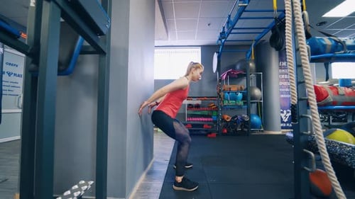 Woman Doing Wall Sit Exercise at the Gym